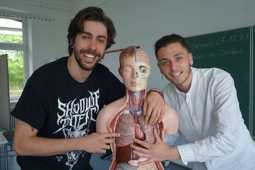 Schüler lernen an einem Modell des menschlichen Körpers.