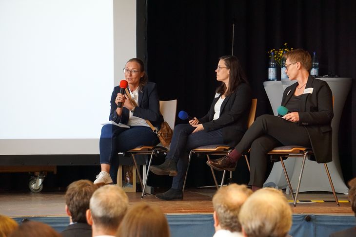 Teilnehmer der Podiumsdiskussion auf der Bühne