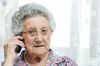 ältere Dame mit grauen Locken telefoniert mit ernstem Gesicht