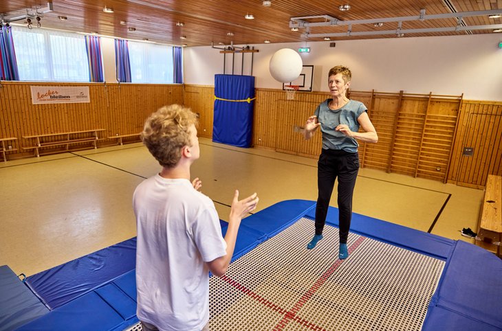 Zwei Menschen springen auf einem Trampolin