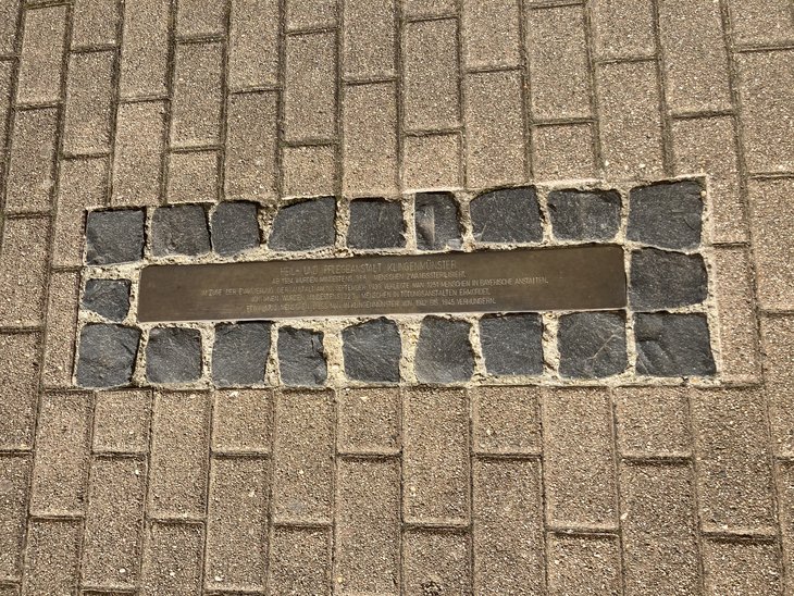 Die goldfarbene Stolperschwelle trägt die Inschrift: Schriftzug „Heil- und Pflegeanstalt Klingenmünster. Ab 1934 wurden mindestens 366 Menschen zwangssterilisiert. Im Zuge der Evakuierung der Anstalt am 10. September 1939 verlegte man 1251 Menschen in bayerische Anstalten. Von ihnen wurden mindestens 223 Menschen in Tötungsanstalten ermordet. Etwa 1700 Menschen ließ man in Klingenmünster von 1942 bis 1945 verhungern.“
