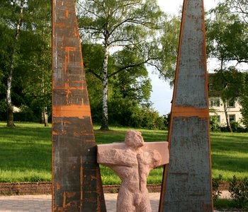 Die Gedenkstätte des Pfalzklinikums: eine Steinfigur ist eingeklemmt zwischen zwei Metallstücke.