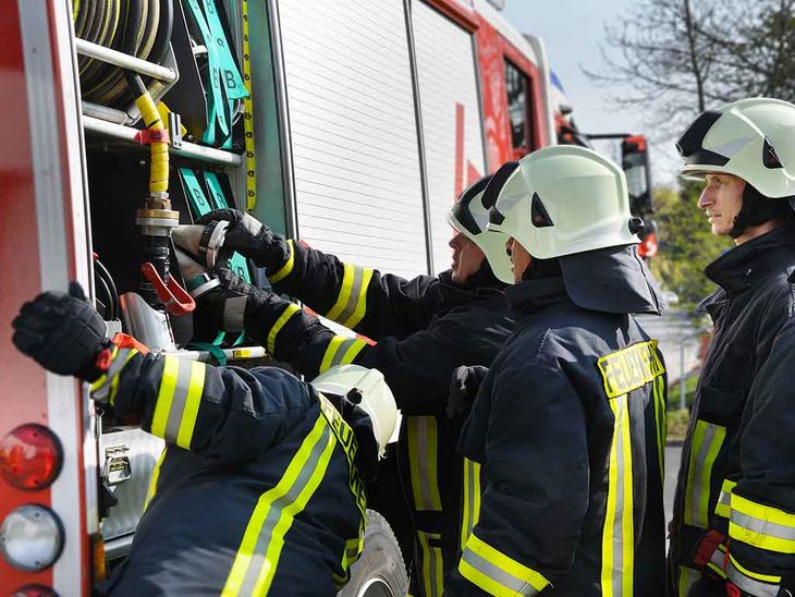 man sieht die Werkfeuerwehr vor einem Feuerwehrauto 