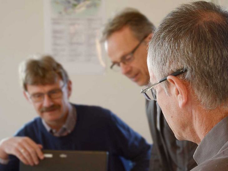 drei Männer sind für das Qualitätsmanagement in einer Gesprächssituation.