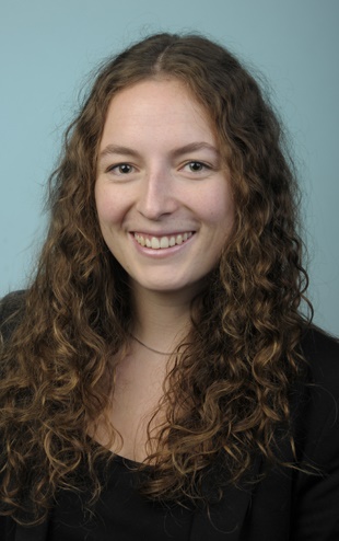 Das Bild zeigt Lara Heß: eine junge Frau, mit langen, dunklen Locken